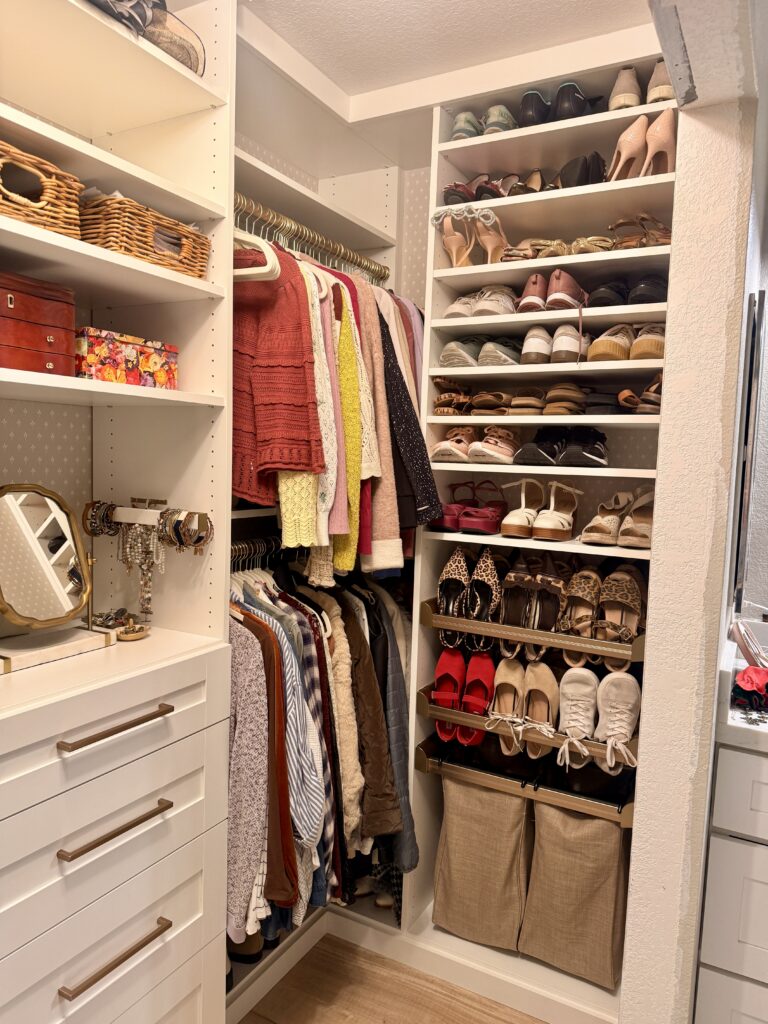 Behind the Wall: What My Closet Taught Me About Needs Assessment Custom walk-in closet with white built-in shelving, drawers, hanging clothes, and organized shoes, used as a visual metaphor for uncovering hidden problems before designing solutions.