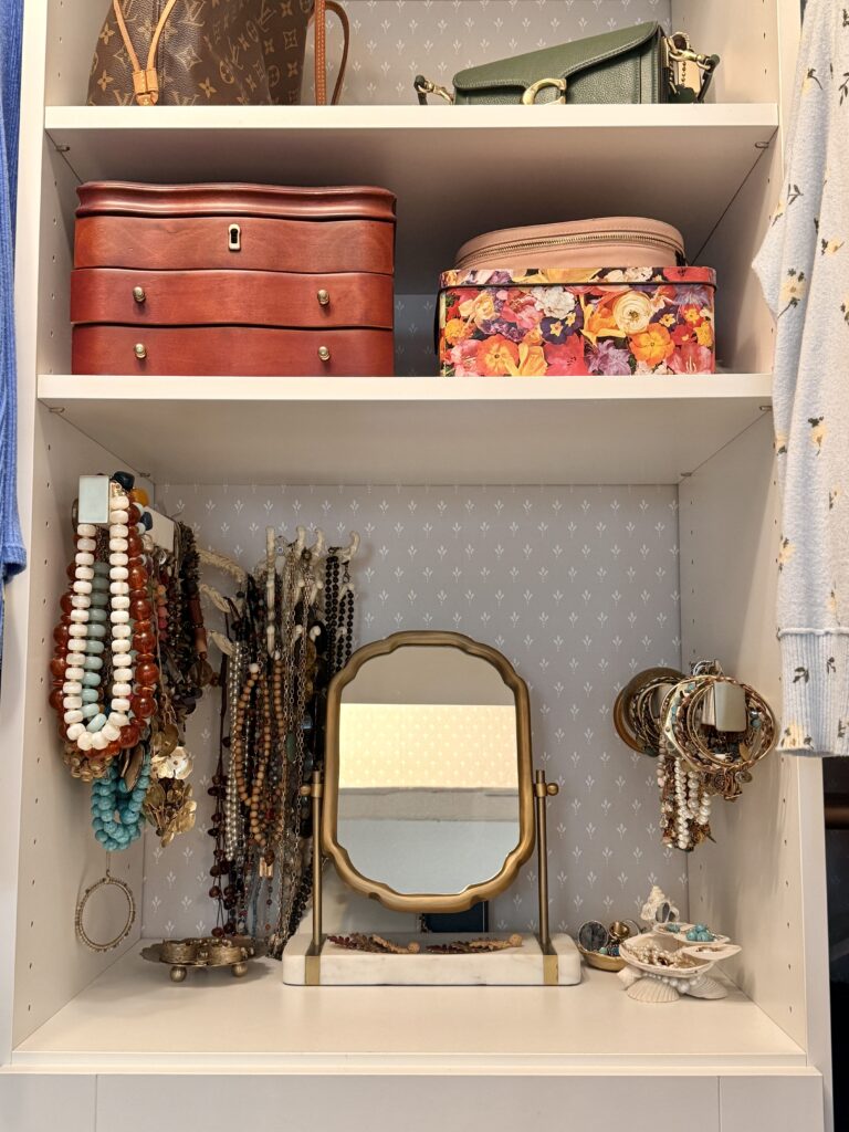 Close-up of a remodeled master closet featuring a jewelry display, decorative wallpaper, and mirror, symbolizing the importance of looking beneath the surface to understand the real problem.